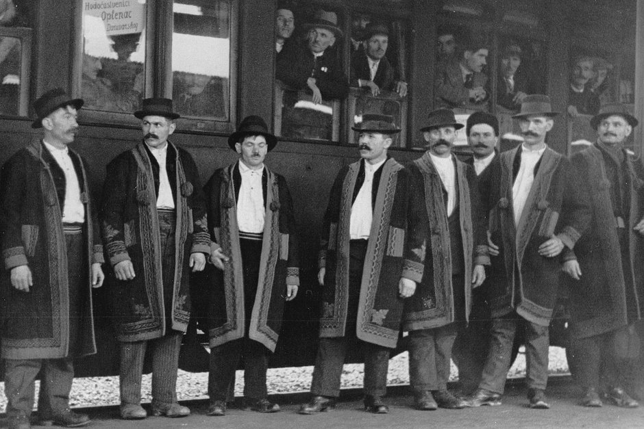 Мужчины в традиционных сербских костюмах перед «поездом паломников», направляющимся к церкви Святого Георгия и месту захоронения династии Карагеоргиевичей недалеко от Тополы, юг Белграда, 1934 год