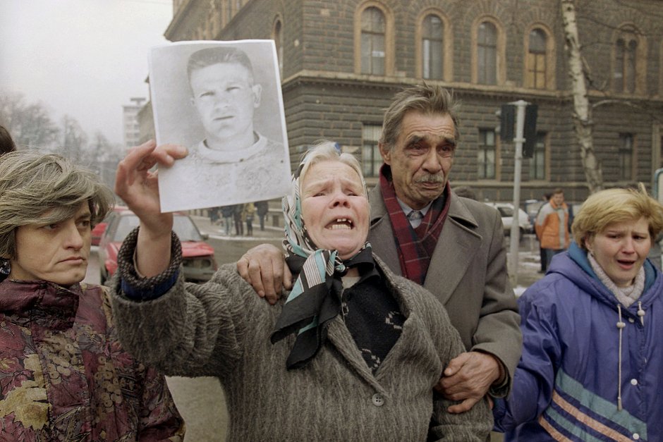 Женщина показывает фотографию своего погибшего в столкновениях сына перед зданием президента Боснии в Сараево, 28 января 1993 года