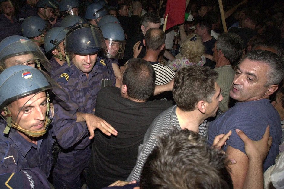 Сторонники бывшего президента Слободана Милошевича толкаются с сербской полицией перед зданием правительства Югославии во время акции протеста в Белграде, 26 июня 2001 года