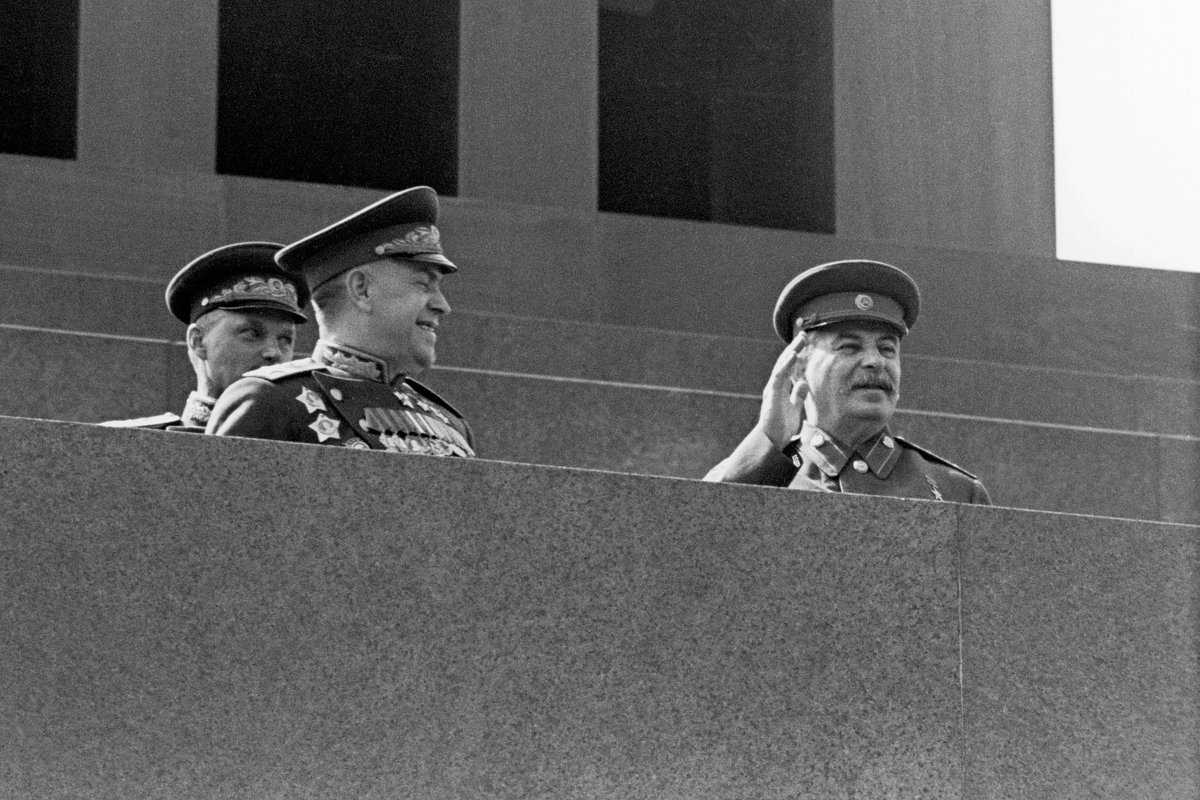 Маршалы Советского Союза Георгий Жуков (слева) и Иосиф Сталин на трибуне мавзолея во время парада Победы 1945 года. За плечом Жукова стоит маршал Советского Союза Константин Рокоссовский