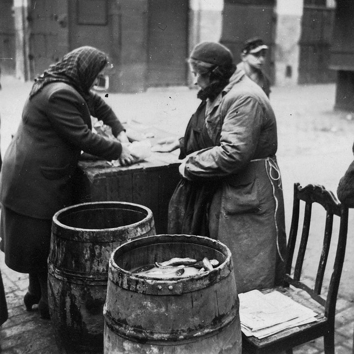 Еврейка продает моченые бочковые огурцы на улице Варшавского гетто. Варшава, Польша. 1940 год