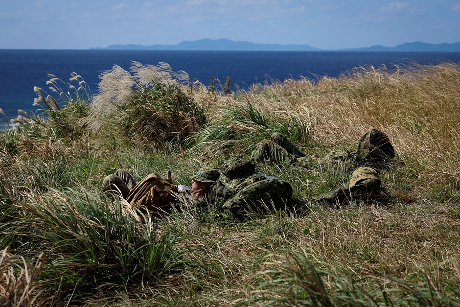 Солдаты десантной бригады быстрого развертывания Сухопутных сил самообороны Японии отдыхают после военных учений на необитаемом острове Ирисуна недалеко от Окинавы, Япония, 15 ноября 2023 года