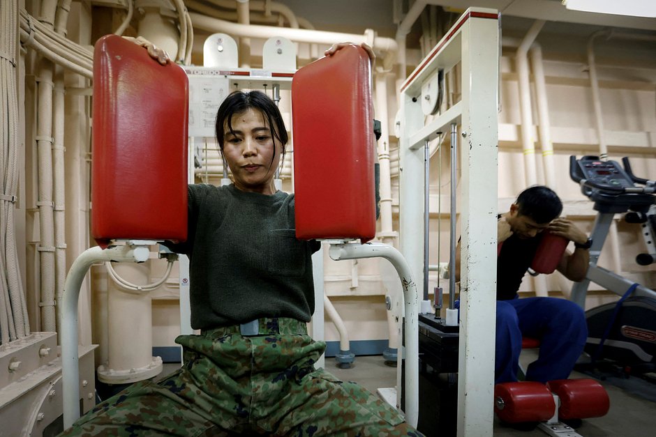 Хироки Маруяма, 38 лет, солдат десантной бригады быстрого развертывания Сухопутных сил самообороны Японии тренируется в спортзале на транспортном судне JS Osumi (LST-4001) в водах недалеко от Окинавы, Япония, 14 ноября 2023 года