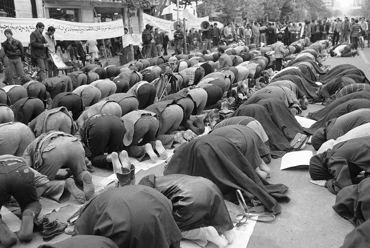 Иранцы молятся возле посольства США в Тегеране за студентов, которые ворвались в здание в воскресенье, взяв в заложники сотрудников. 7 ноября 1979 года 