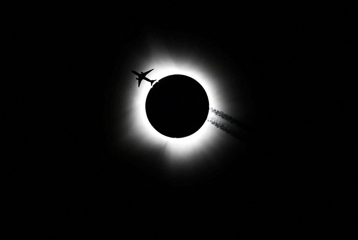 Самолет пролетает вблизи места полного солнечного затмения в Блумингтоне, штат Индиана, США, 8 апреля 2024 года