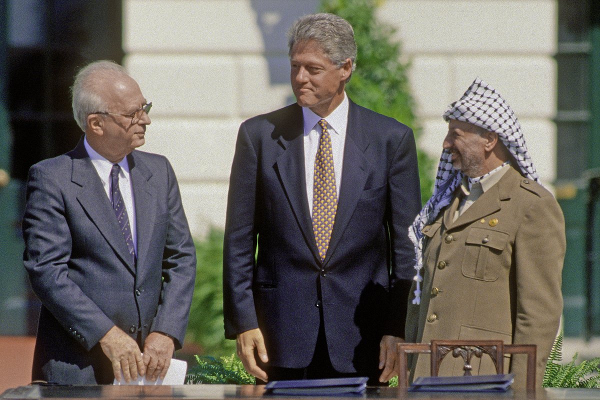 Премьер-министр Израиля Ицхак Рабин, президент США Билл Клинтон и председатель Организации освобождения Палестины Ясир Арафат подписывают мирные соглашения «Осло» в Вашингтоне, США, 13 сентября 1993 года