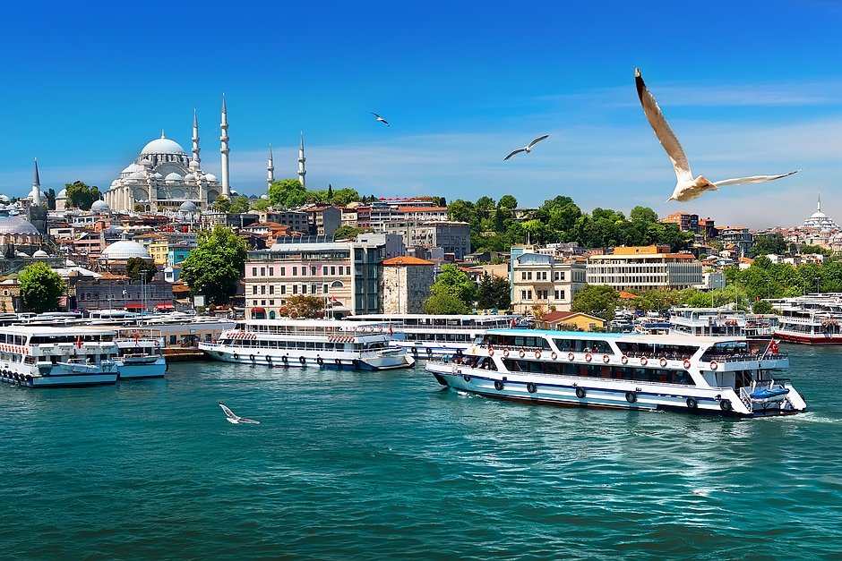 Туристические лодки в бухте Золотой Рог в Стамбуле и вид на мечеть Сулеймание, Турция
