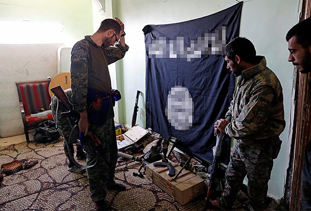 Бойцы Демократических сил Сирии осматривают оружие и боеприпасы, обнаруженные на позициях боевиков «Исламского государства» в Ракке