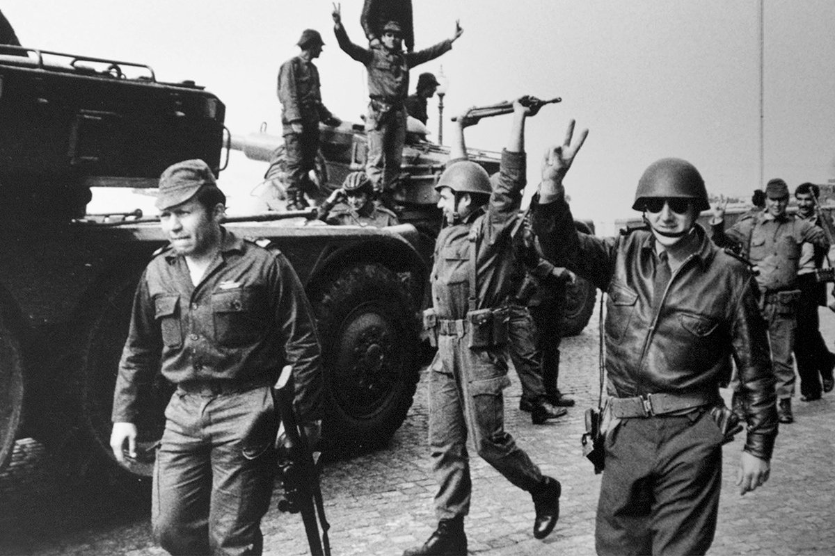 Революционный офицер, капитан Фернанду Жозе Салгейру Майя (слева) и его солдаты после капитуляции власти перед военными в центре Лиссабона, 25 апреля 1974 года