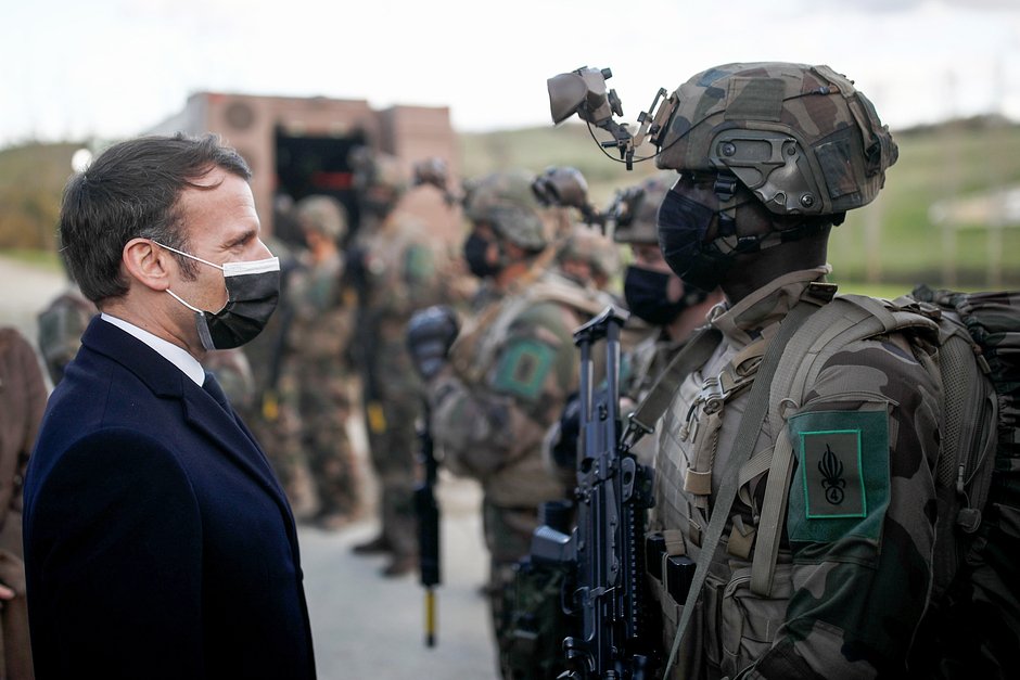 Президент Франции Эммануэль Макрон беседует с солдатом 4-го полка во время посещения Ferme du Cuin, учебного центра 4-го полка Иностранного легиона, в Сен-Годрике, Франция, 12 марта 2021 года