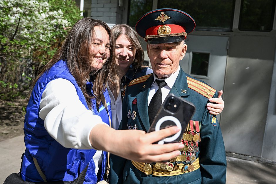 Участники общественного движения «Волонтеры Победы» фотографируются с ветераном Великой Отечественной войны Иваном Петровичем Лыткиным, Москва, Россия, 30 апреля 2024 года