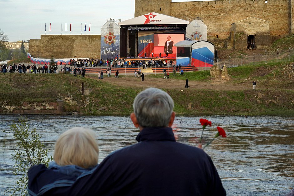 Жители Нарвы через реку смотрят концерт к Дню Победы в российском Ивангороде, Эстония, 9 мая 2023 года
