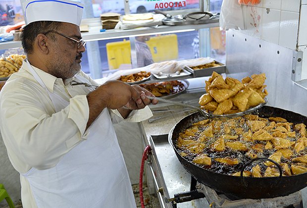 JUNE 26, 2014-DOHA,QATAR: An Pakistani vendor prepares snacks Samosas deep frying in oil during ramadan at restaurant in Doha, Qatar. samosa cooking