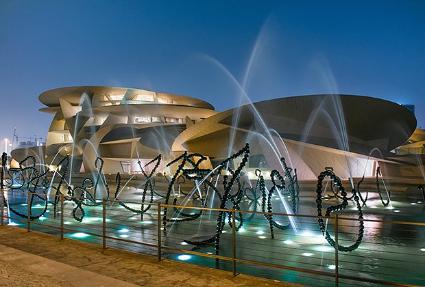 Doha, Qatar - august 2019 : beautiful long exposure image of the National MUseum of Qatar in the night with water fountains in the foreground.