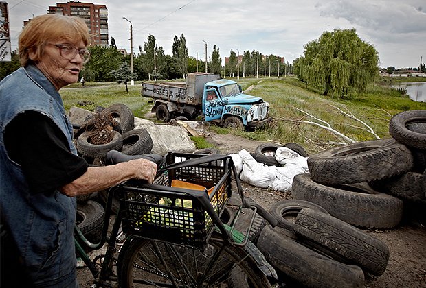 Местная жительница у разрушенного блокпоста на одной из улиц города Славянска