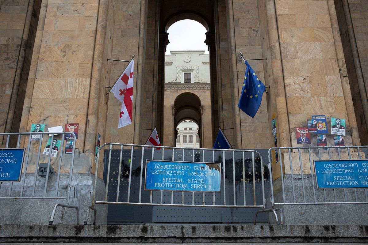 Флаги Грузии и Европейского союза над баррикадами у входа в здание парламента в Тбилиси, Грузия, 14 мая 2024 года