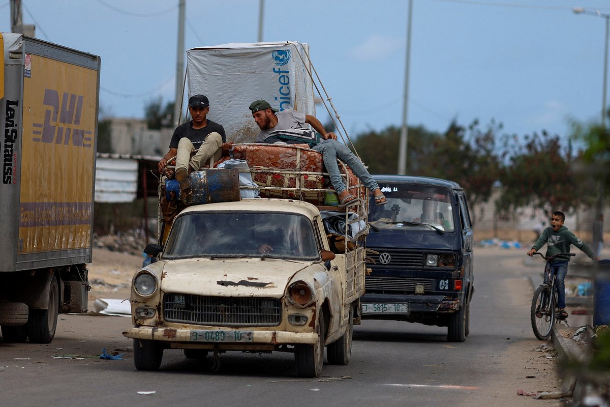 Палестинцы едут на автомобиле, покидая Рафах после того, как израильские силы начали наземную и воздушную операцию, юг сектора Газа, 13 мая 2024 года