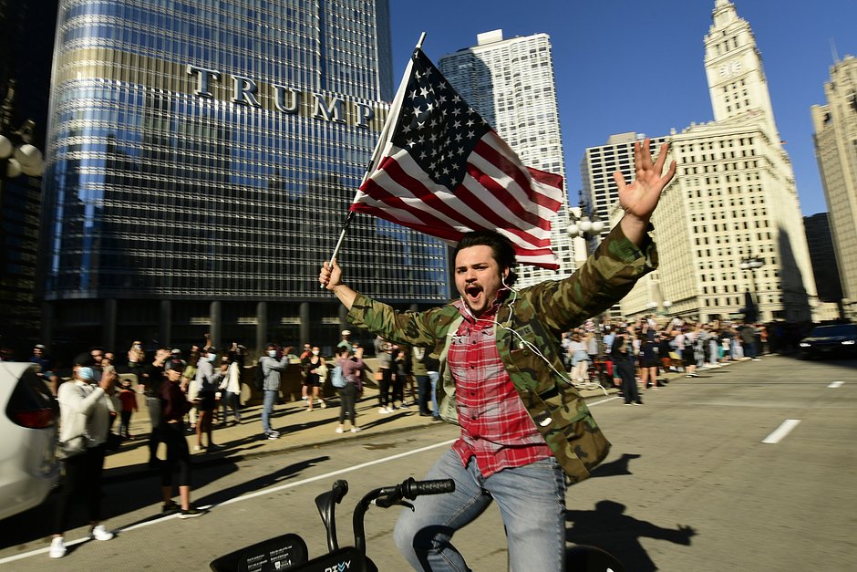 Сторонники Джо Байдена празднуют его победу на выборах на фоне Trump Tower