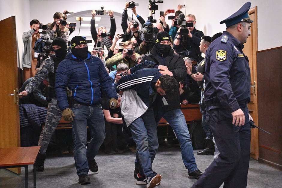 Далержон Мирзоев (в центре), задержанный по подозрению в террористическом акте в «Крокус Сити Холле», в здании Басманного суда Москвы, где проходит избрание меры пресечения в отношении четырех задержанных подозреваемых