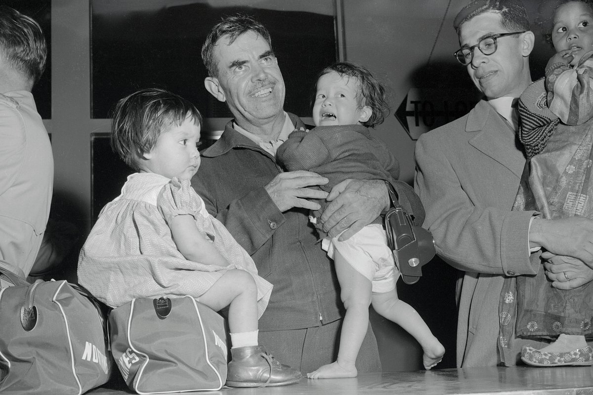 Гарри Холт представляет двух из 12 корейских сирот, прибывших к нему на усыновление, таможенникам, 7 апреля 1956 года