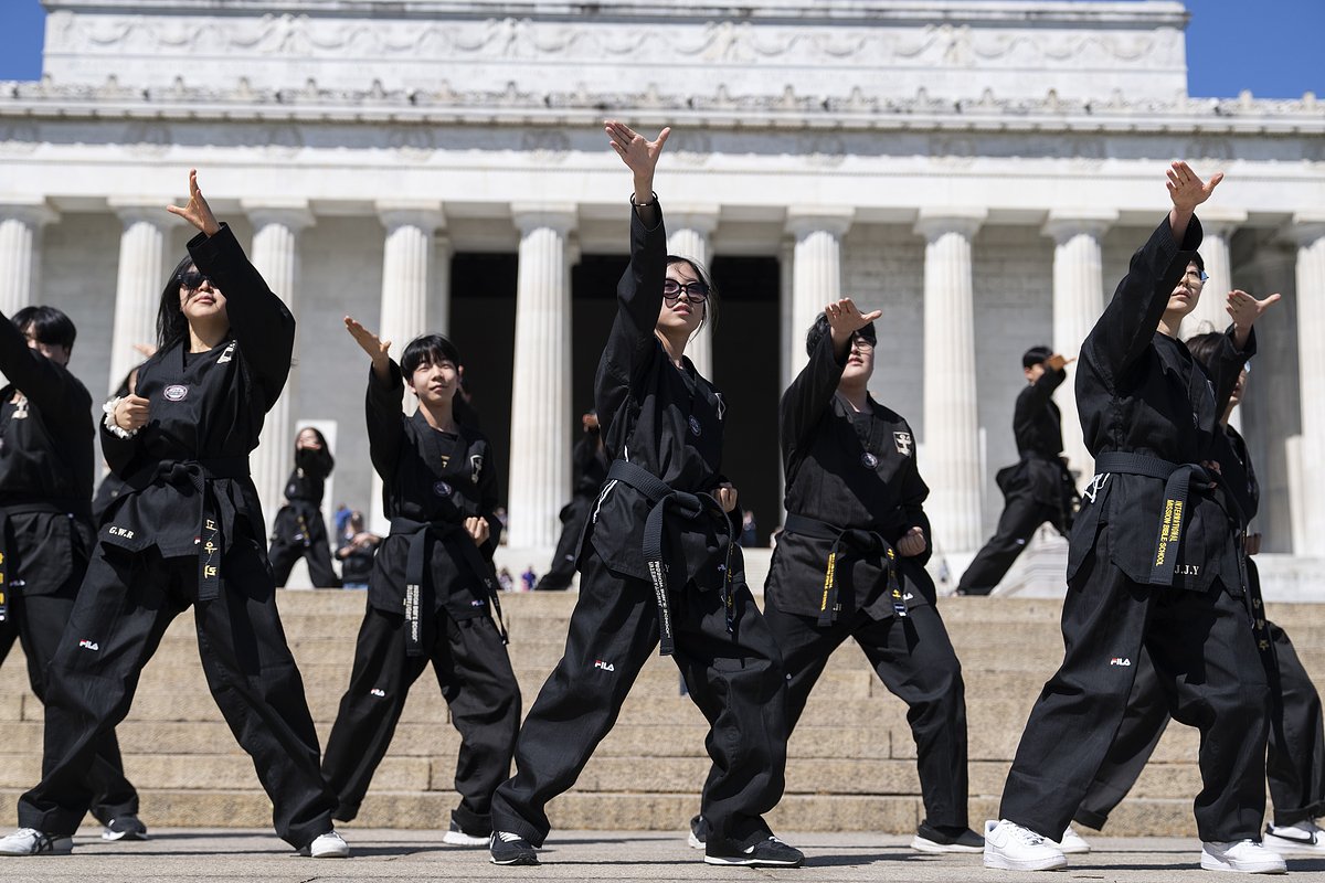 Группа школьников из Южной Кореи демонстрирует боевые искусства возле Мемориала Линкольна, США, 17 апреля 2023 года