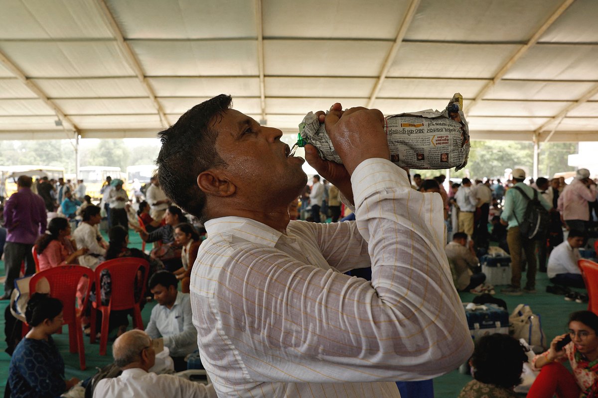 Сотрудник избирательного участка пьет воду на участке в Варанаси, Индия, 31 мая 2024 года 