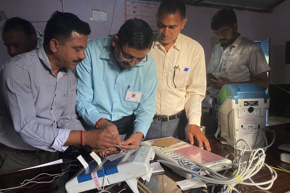 Сотрудники избирательных участков проверяют и опечатывают электронную машину для голосования в Дхарамшале, Индия, 1 июня 2024 года 