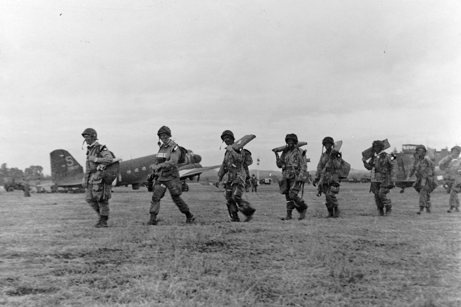 Американские парашютисты идут к транспортному самолету для вторжения в Нормандию 