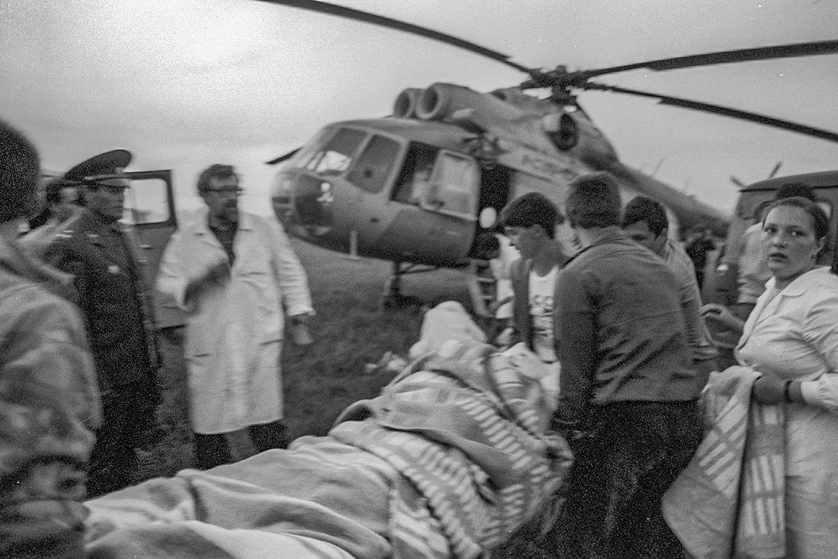 Местные жители и курсанты эвакуируют раненых из села Ушу-Теляк рано утром 4 июня 1989 года