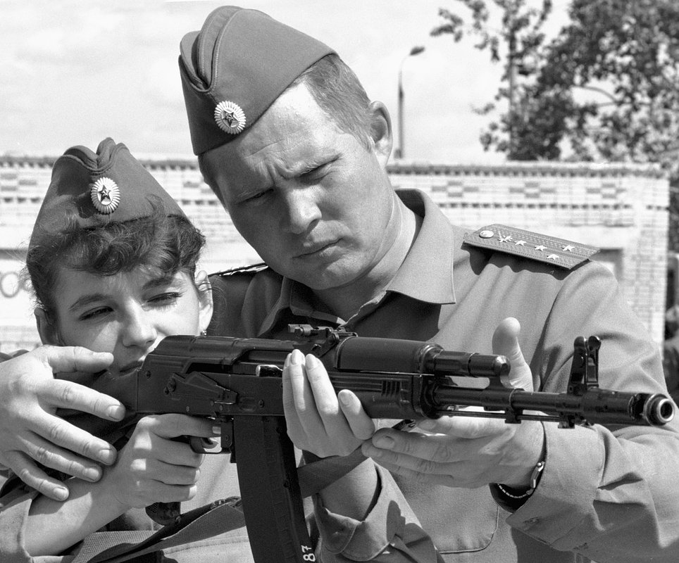 Заместитель командира роты А. Довгерд обучает курсантку стрелять из автомата Калашникова