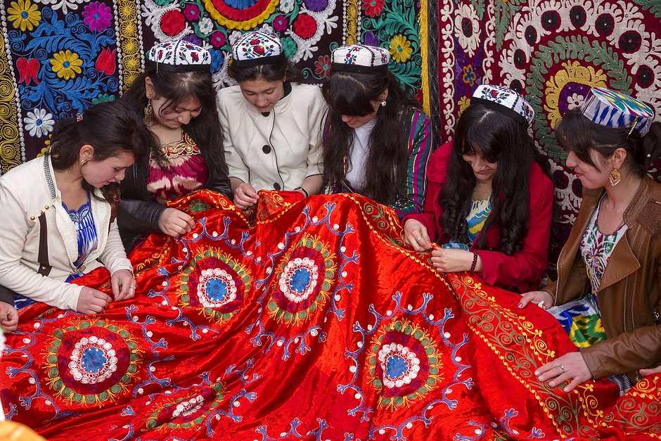 Таджикские девушки вышивают ковер во время праздника весны ― Навруза 