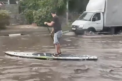 Плывущий на сапборде по затопленному городу россиянин попал на видео