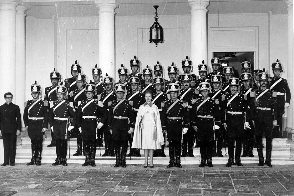 Президент Аргентины Исабель Перон вместе с охраной на ступенях президентской резиденции в Оливосе на окраине Буэнос-Айреса, Аргентина, 25 мая 1975 года 