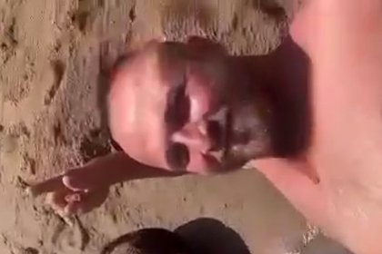 Улыбающийся россиянин позировал с прибитым к берегу утопленником и попал на видео