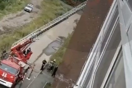 При эвакуации из окна дома россиянка слетела с пожарной лестницы и попала на видео