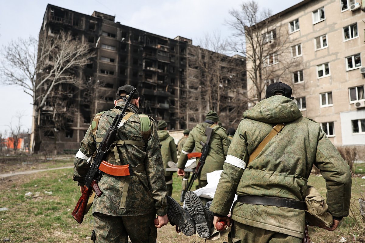 Военнослужащие Народной милиции ДНР несут носилки с телом погибшего сослуживца, Мариуполь, 2 апреля 2022 года