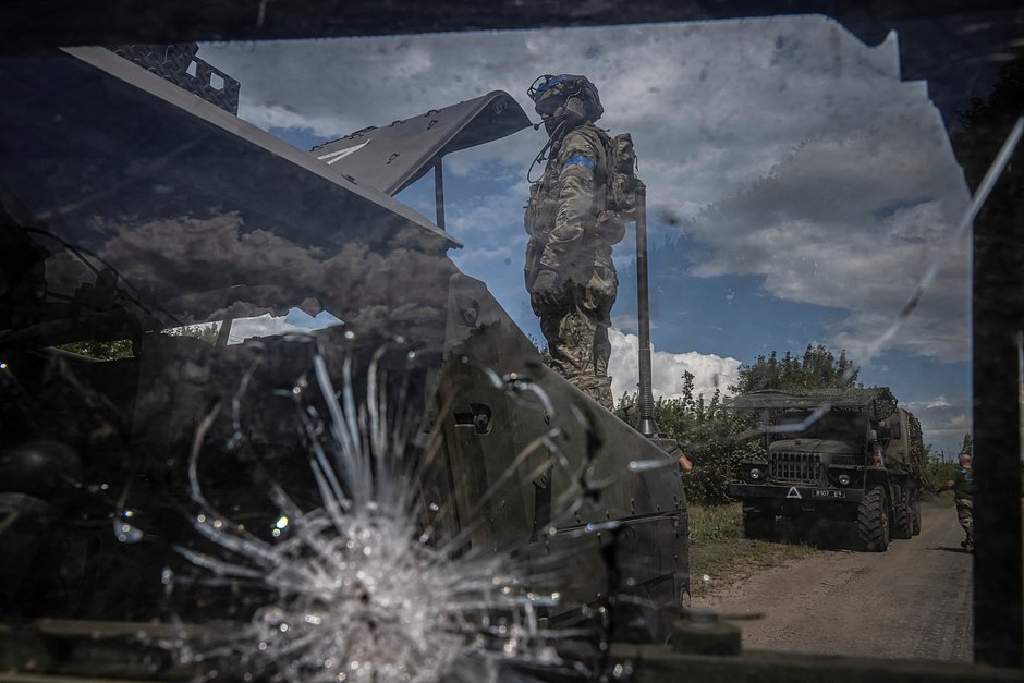 Украинский военный чинит бронированный автомобиль недалеко от границы с Курской областью, 11 августа 2024 года