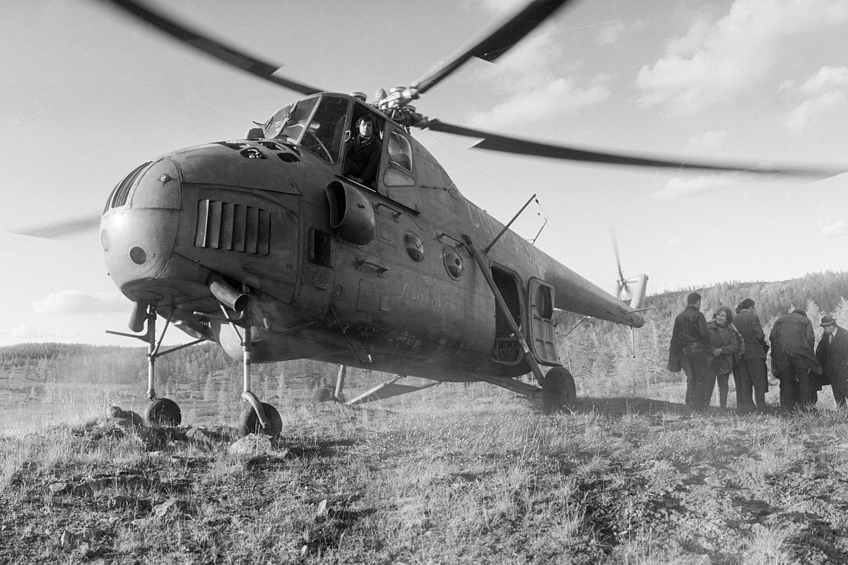 Вертолет Ми-4, совершивший посадку в поле, ожидает геологов 