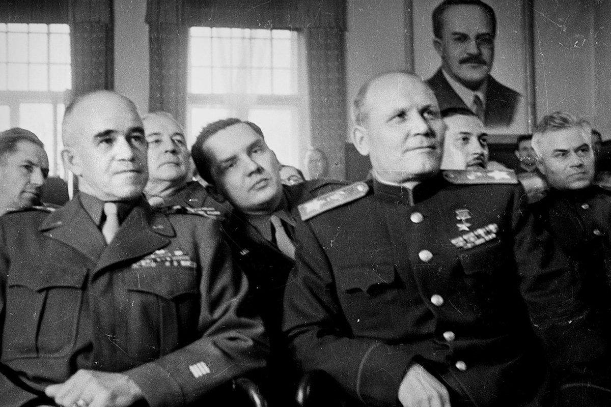 Маршал Конев и генерал Брэдли смотрят концерт фронтового красноармейского ансамбля. В начале программы хор красноармейцев исполнил государственные гимны США и Советского Союза. Красноармейцы, исполнявшие для Брэдли американский гимн, не знали английского, но выучили текст наизусть. Затем выступила «балетная труппа, танцевавшая под аккомпанемент дюжины балалаек». Лебуза, Германия. 5 мая 1945 года