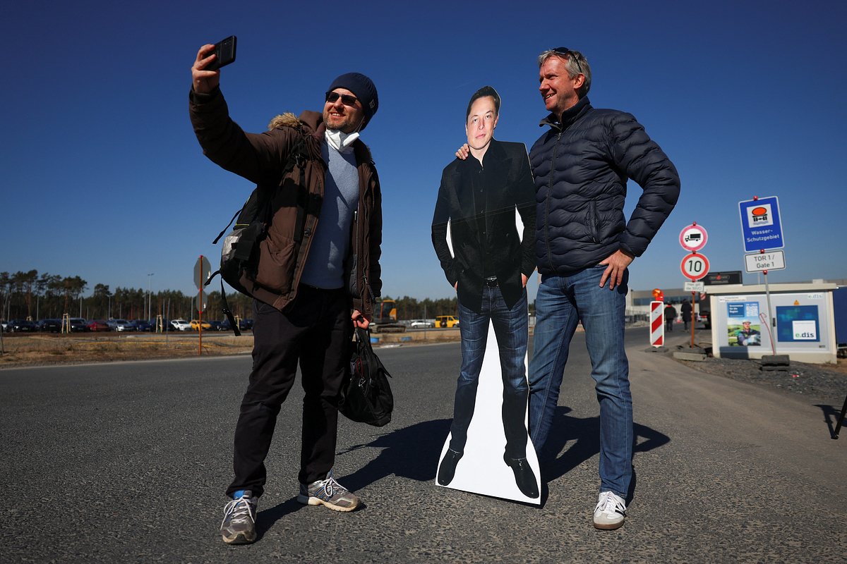 Поклонники генерального директора SpaceX и Tesla Илона Маска фотографируются с его изображением в Грюнхайде, Германия, 22 марта 2022 года