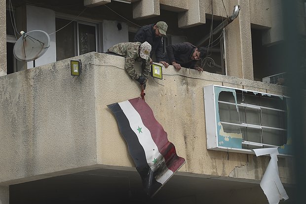 Syrian opposition fighters remove a government Syrian flag from an official building in Salamiyah, east of Hama, Syria Syria, Saturday Dec. 7, 2024. (AP Photo/Ghaith Alsayed)


