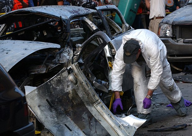 FBI agents inspect the damaged car of slain anti-Syrian journalist Samir Kassir in Beirut June 3, 2005. The United States asked the U.N. Security Council on Friday to expand an investigation into the assassination of former [Lebanese Prime Minister Rafik al-Hariri] to include the killing of a prominent anti-Syria journalist. ??? USE ONLY

