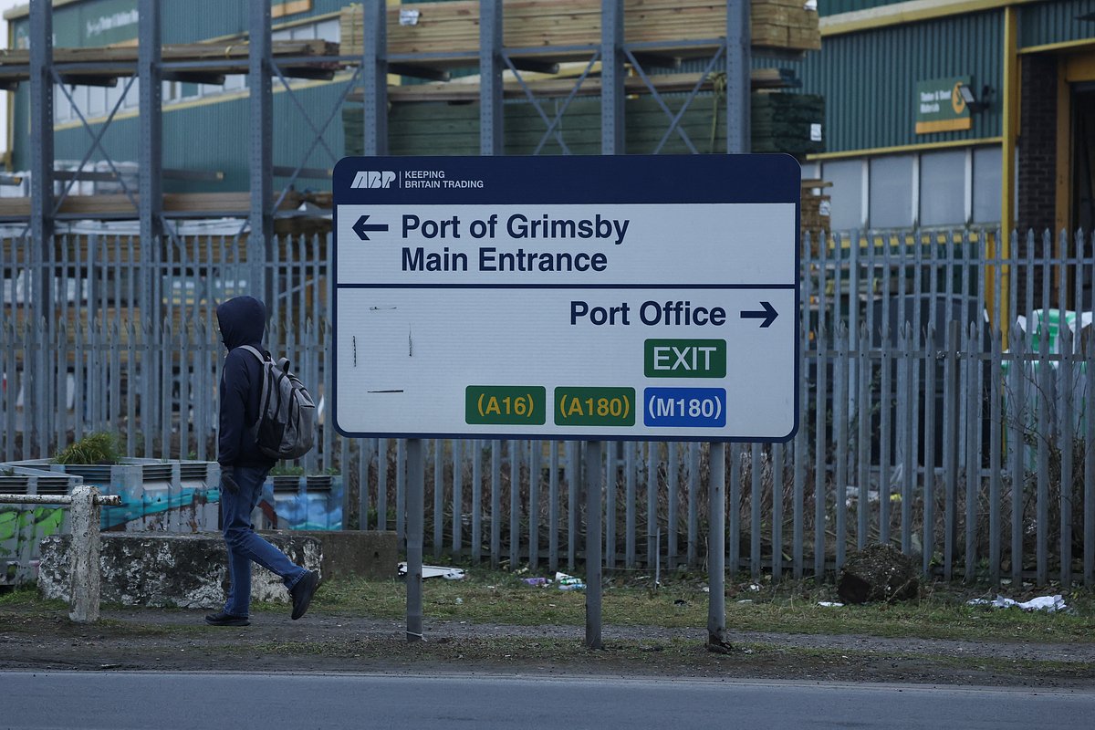 A person walks by a sign for the Port of Grimsby, after a fuel tanker, operated by U.S. company Crowley and owned by Stena, and a container vessel named Solong were involved in a collision off the coast of northeast England, in Grimsby, Britain, March 10, 2025. 