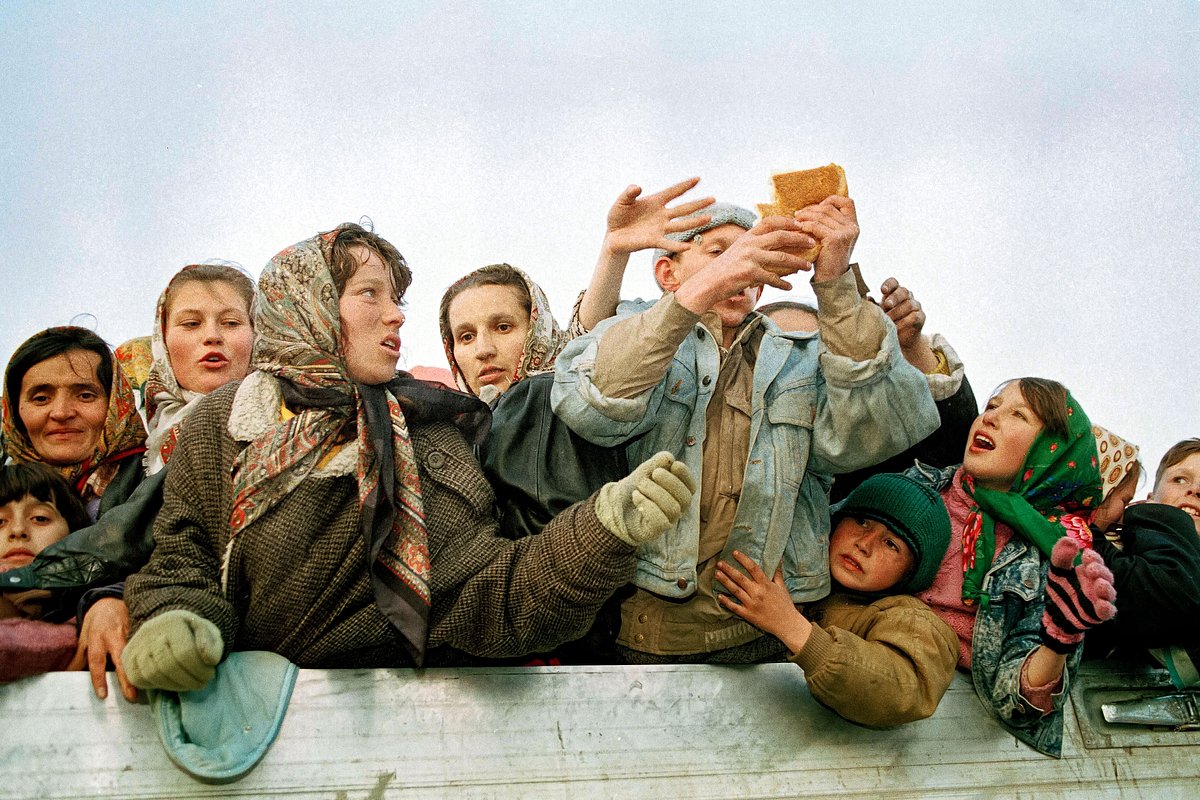 На этой фотографии, сделанной 29 марта 1993 года, беженцы, эвакуированные из осажденного мусульманского анклава Сребреница, борются за хлеб по прибытии в Тузлу, Босния.