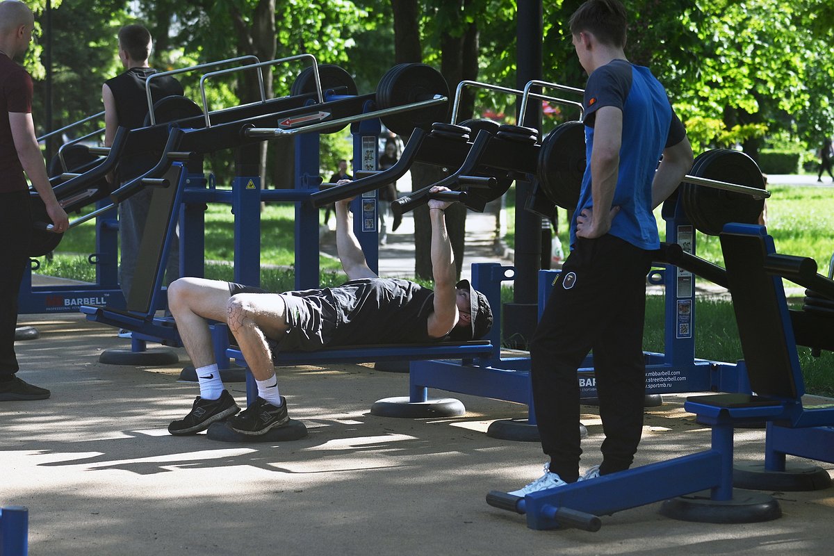 Молодые люди на спортивной площадке в сквере