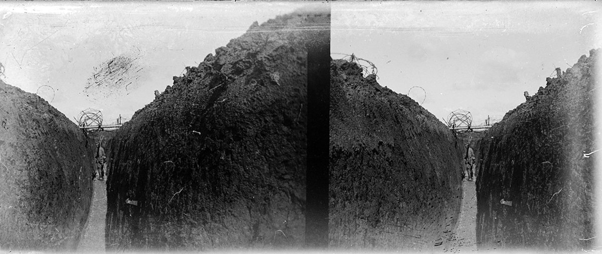 Немецкий солдат идет по одной из многокилометровых траншей. Сверху видно заграждение из колючей проволоки. Франция. 1914-1915 годы