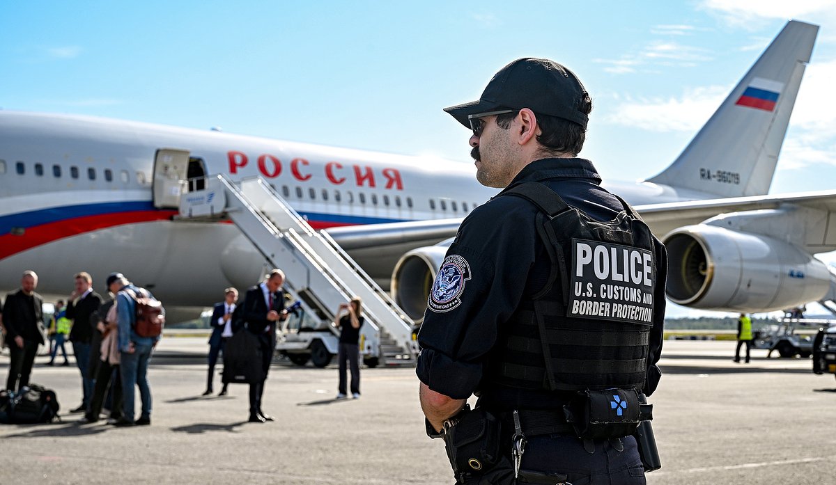 Сотрудник полиции США на фоне самолета Ил-96-300 «России» в аэропорту Анкоридж на Аляске