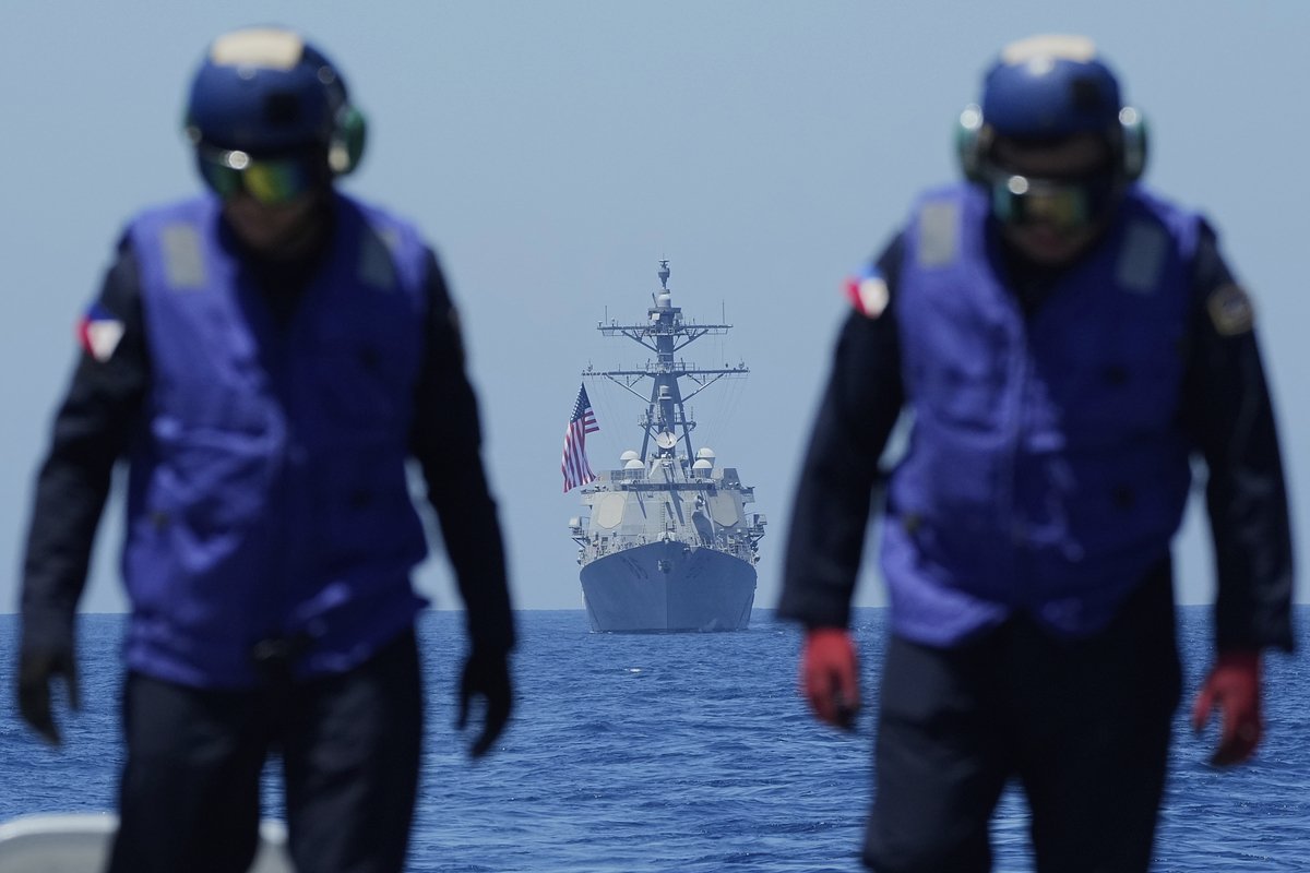 Персонал на борту корабля ВМС Филиппин «Хосе Рисаль» проверяет полетную палубу во время учений с США и Японией, Южно-Китайское море, 28 марта 2025 года