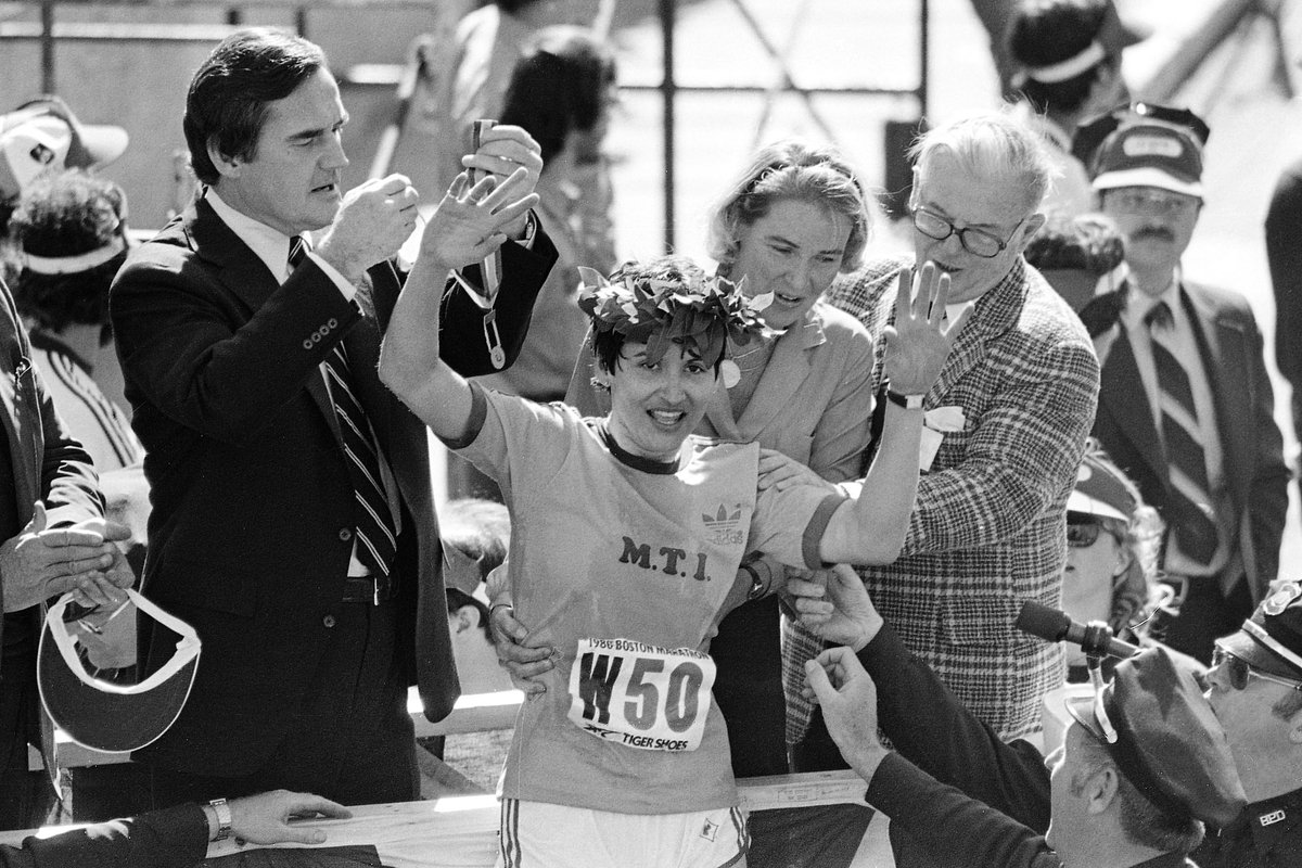 Rosie Ruiz of New York waves to the crowd after receiving the laurel wreath from Boston's Mayor's wife, Katherine White, second from right, and about the receiver medal from Gov. Edward J. King, second from left, after being announced winner of the women's division of the Boston Marathon, April 21, 1980