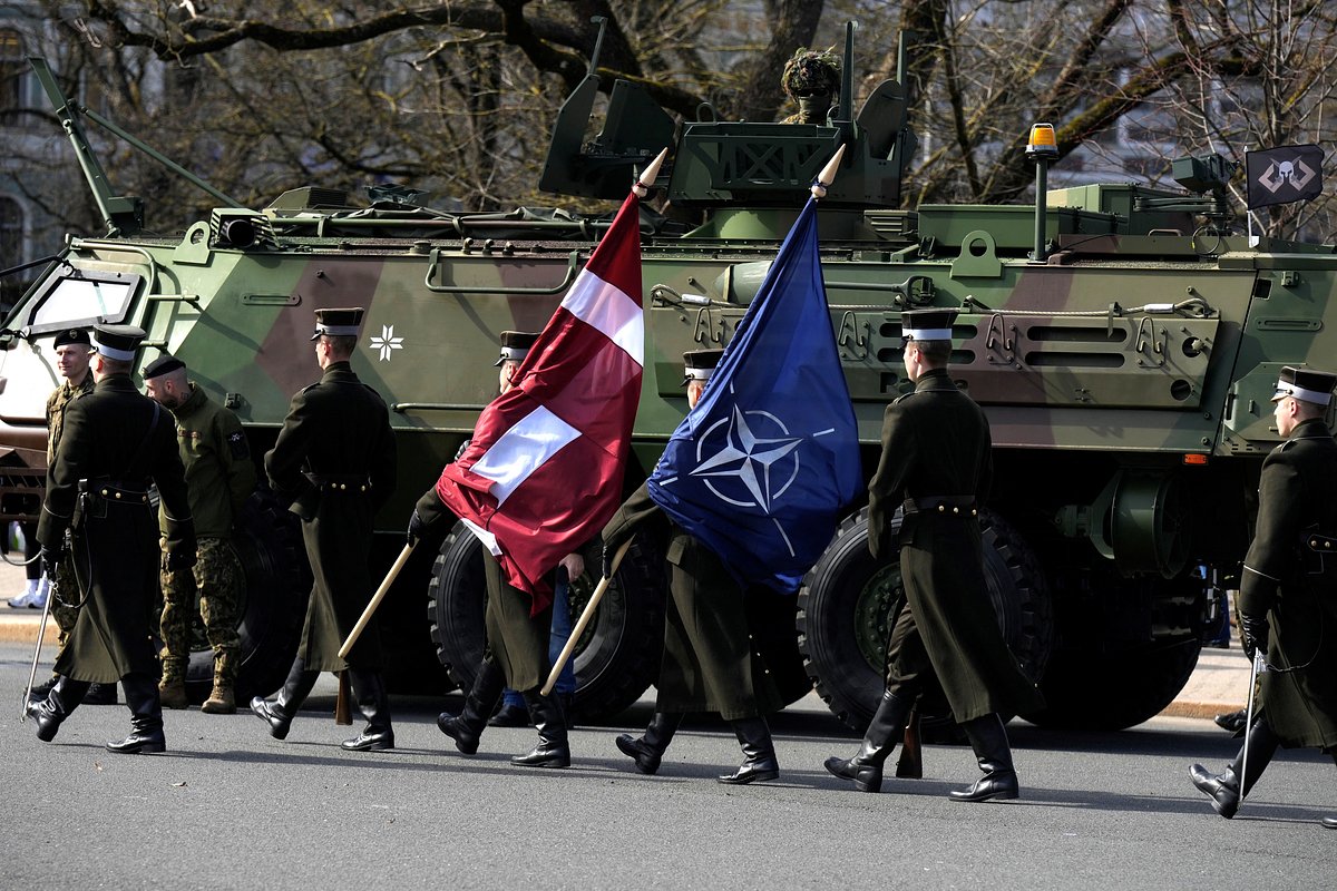 Военнослужащие с флагами Латвии и НАТО во время празднования годовщины вступления прибалтийской республики в альянс, Рига, Латвия, 28 марта 2024 года